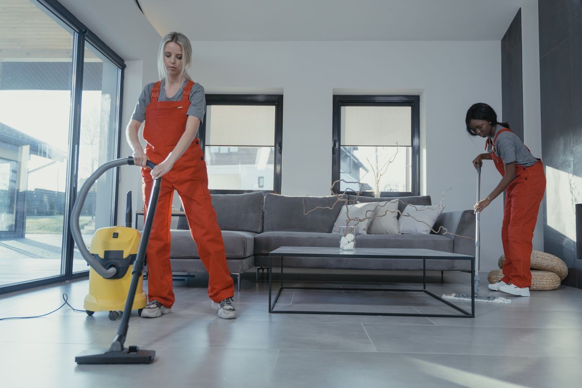 Cleaner wiping down a bright living room